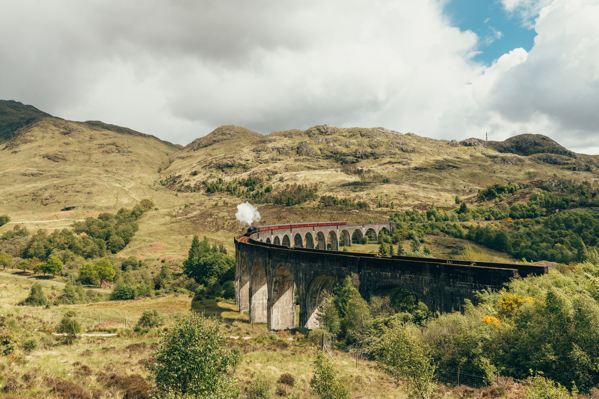 a train on a bridge in the countryside