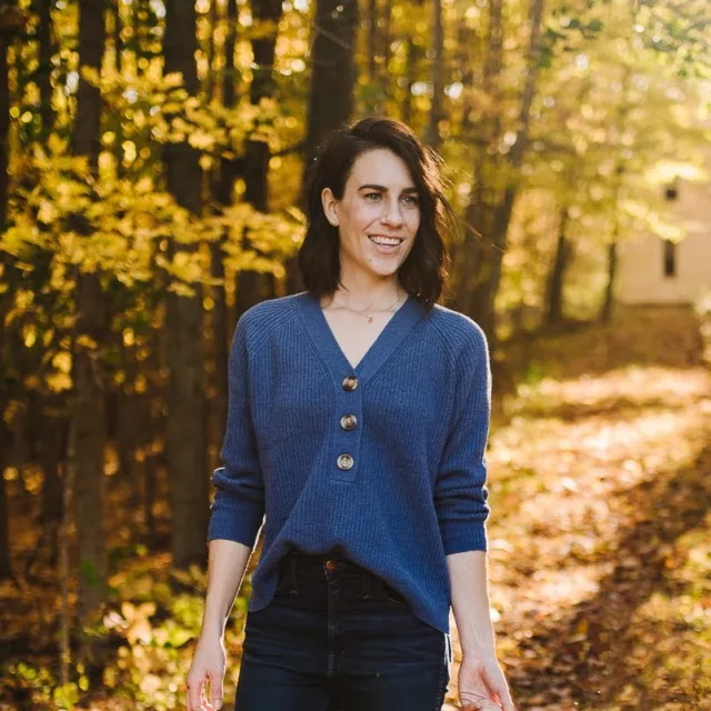 Picture of Marlaena walking in forest wearing a blue sweater and dark jeans