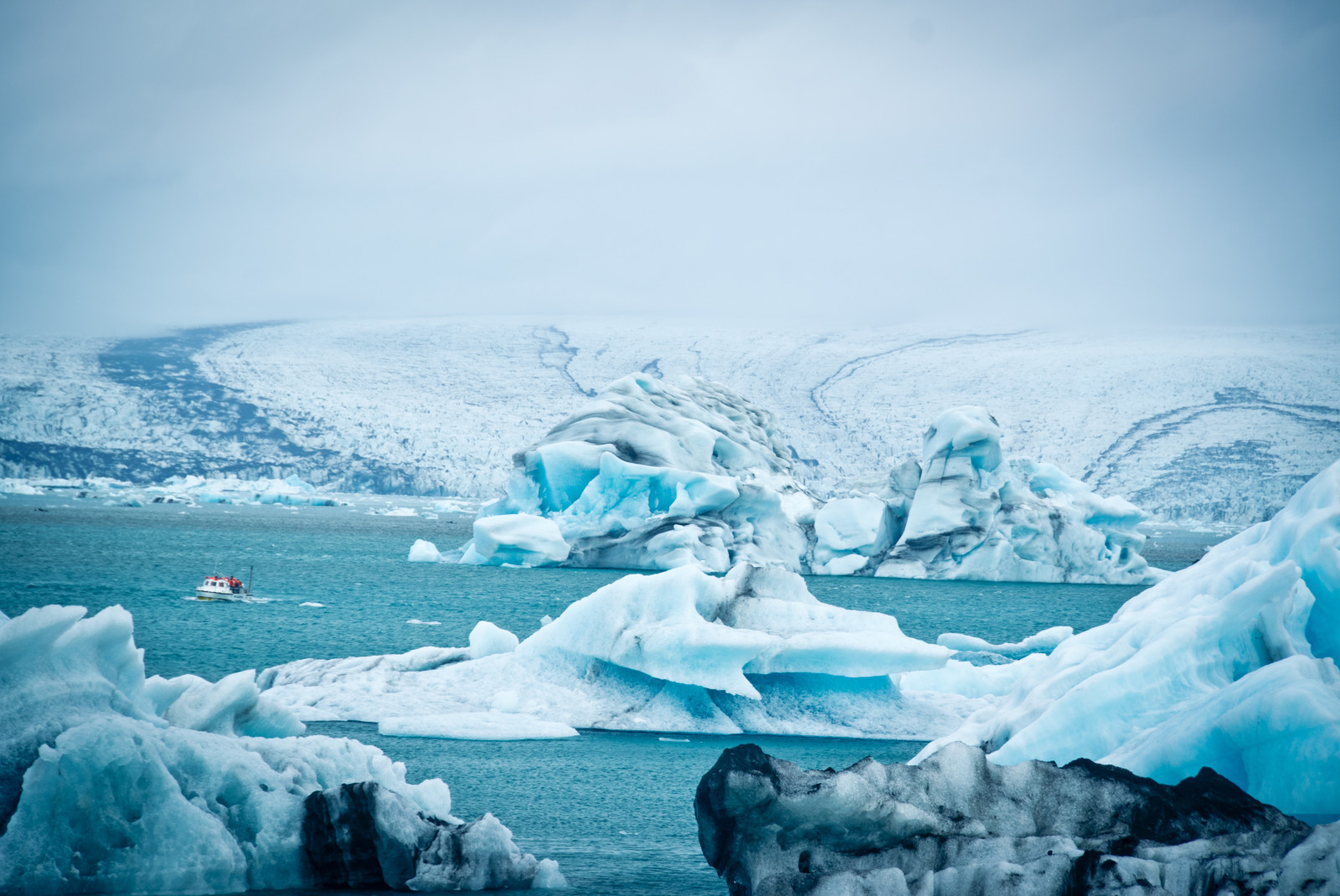 Body of water and ice pillars with cloudy skies