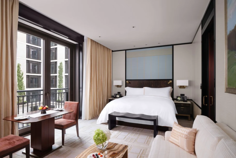 chic hotel room with a white bed and black-bordered floor-to-ceiling windows
