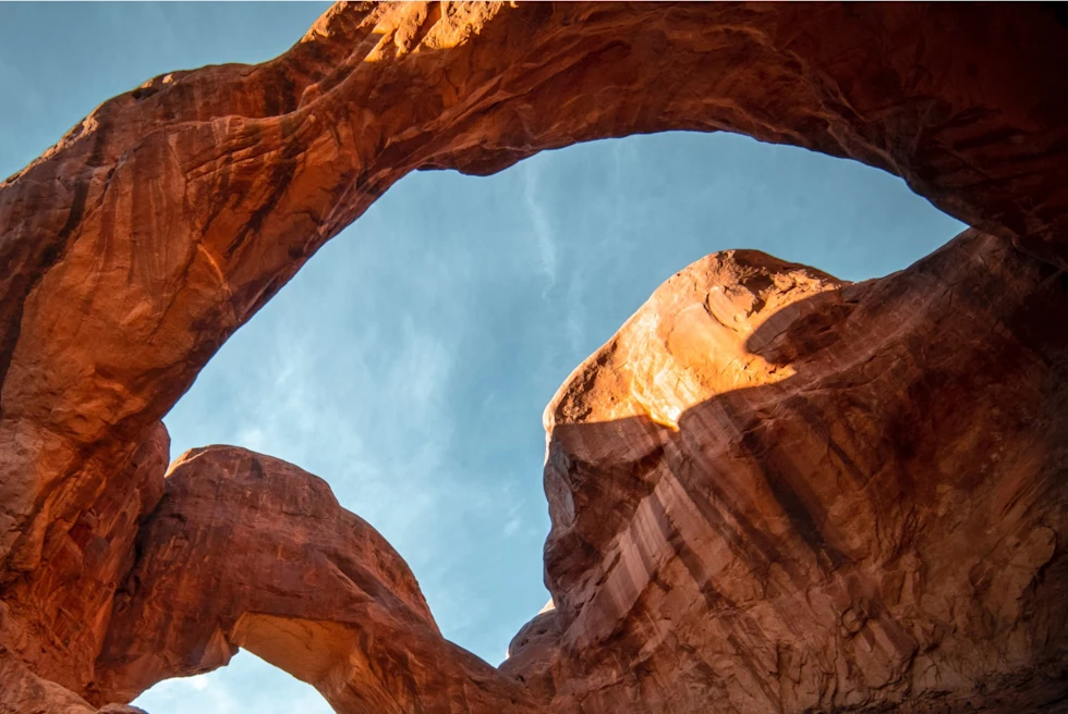 low-angle view of red-rock formations against a blue sky