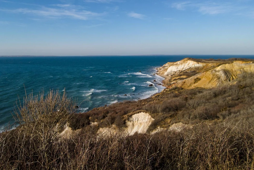 natural cliffs over the ocean with crashing waves on a clear sunny day