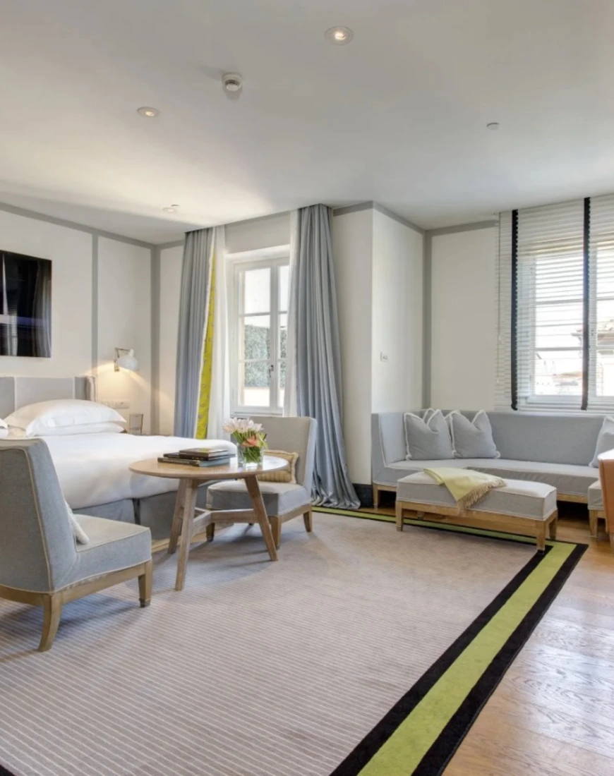 bright bedroom with a desk, sofa and chairs