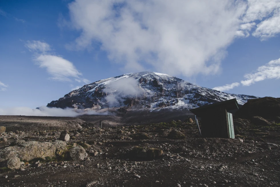 Mount Kilimanjaro in Tanzania from a distance brown rocky valley with a tall snow capped mountain