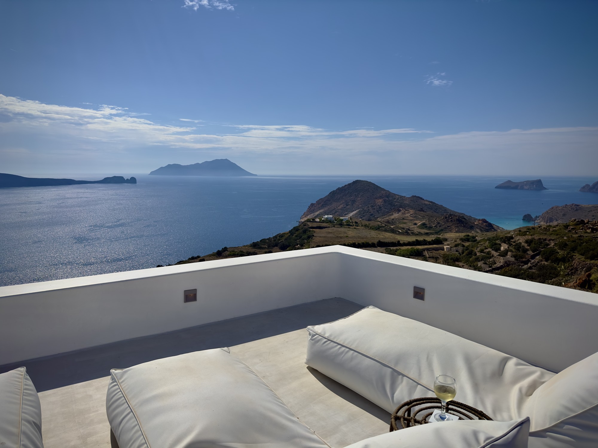 Outdoor balcony with floor sitting and view of ocean.