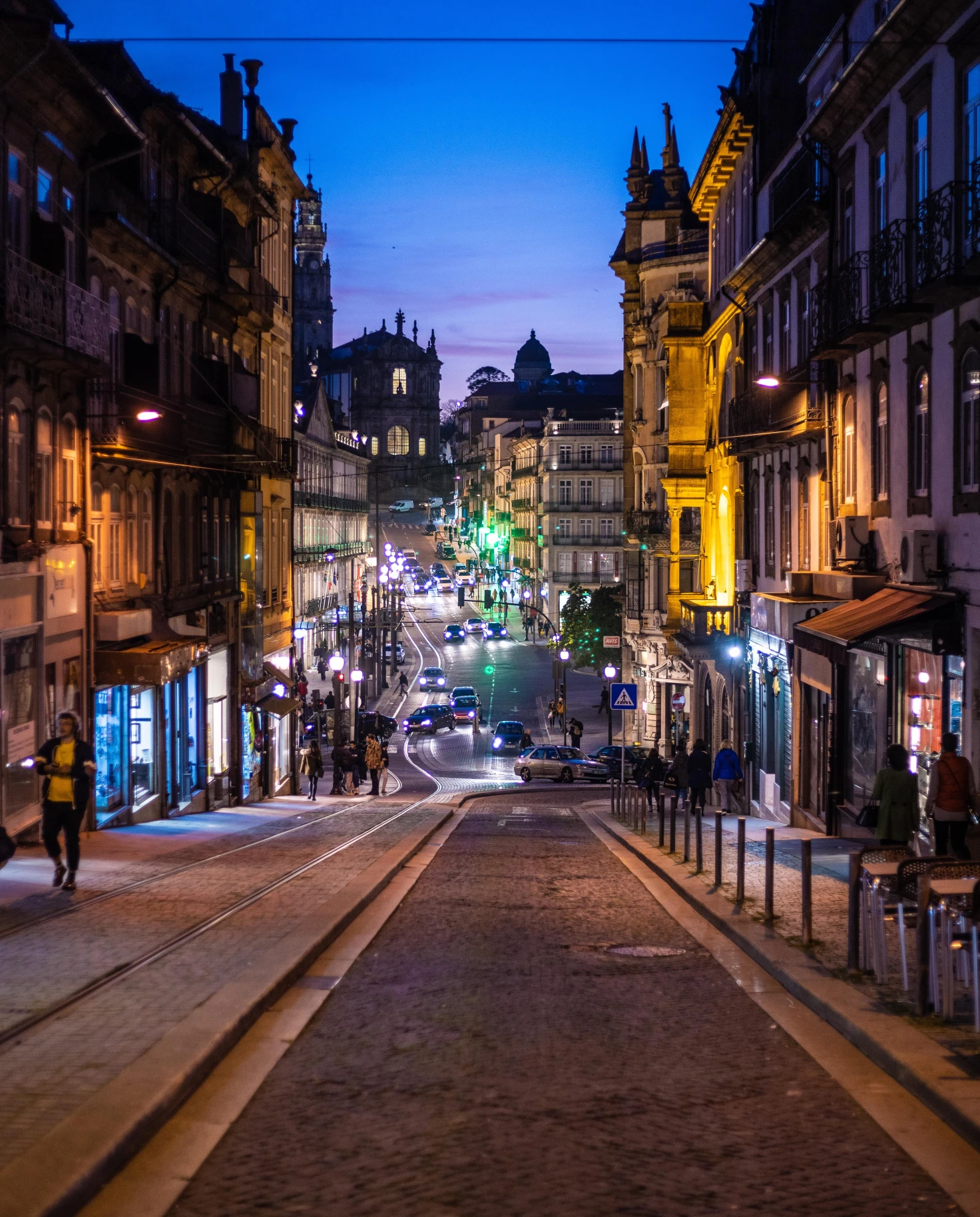 A street on a hill at night in Porto, Portugal. 