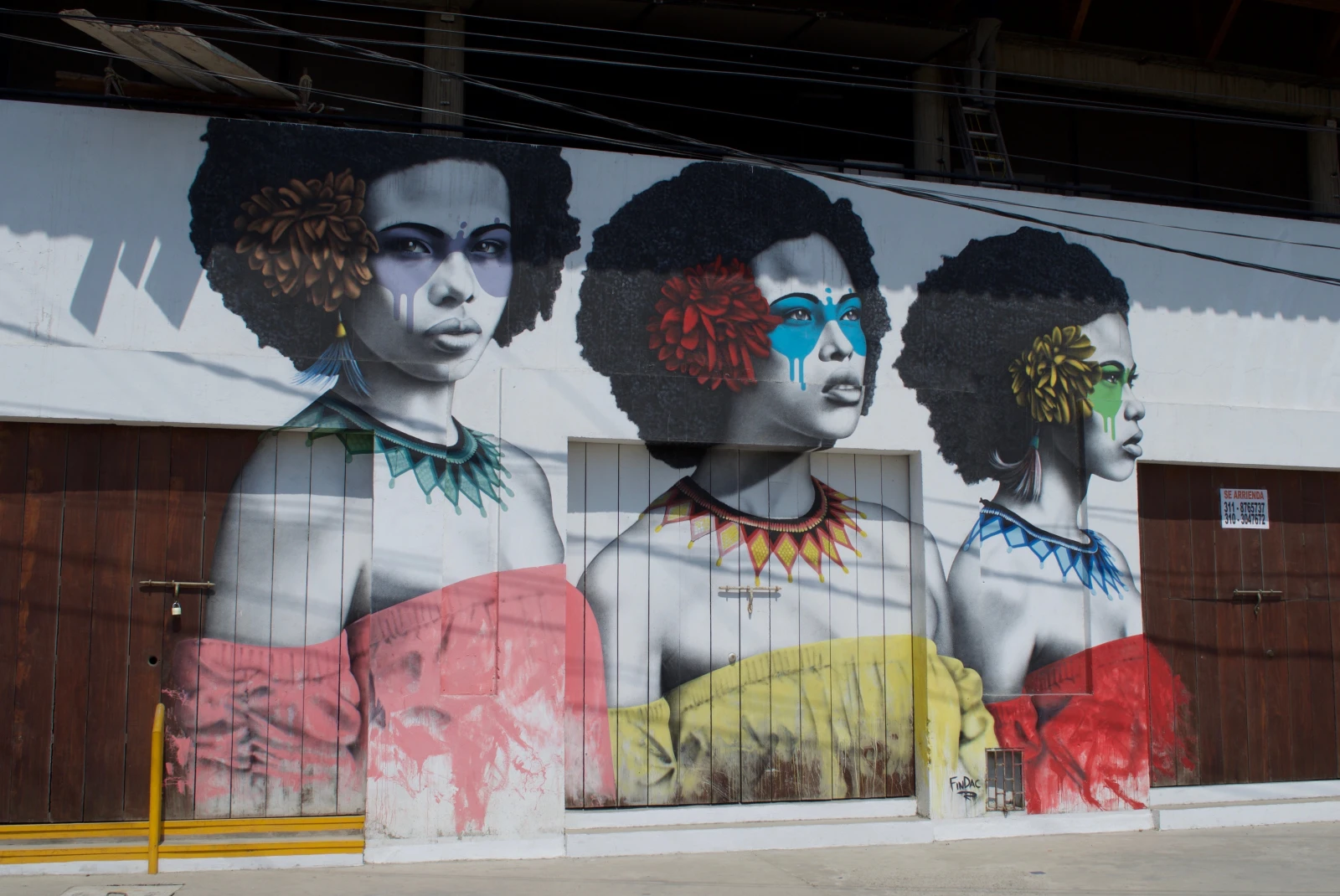 A wall painted with women with different colored dress shirts.