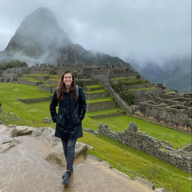 Travel Advisor Rebecca Lefebvre in a black coat in front of Machu Picchu.