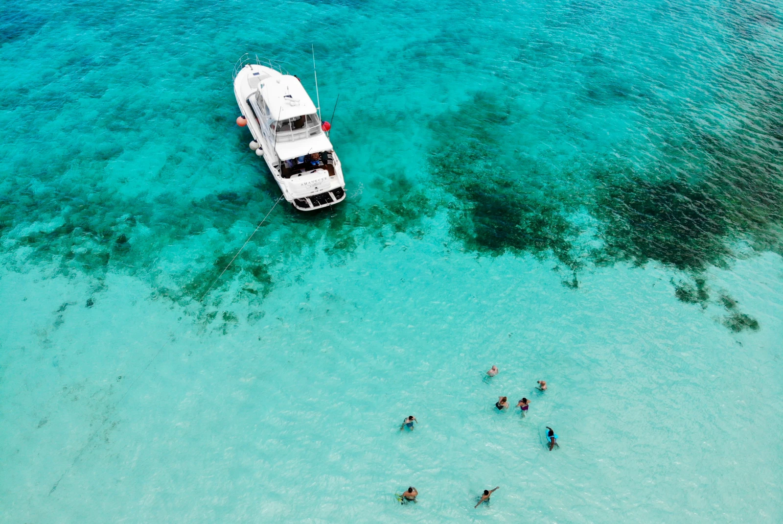 aerial view of turquoise water with people swimming