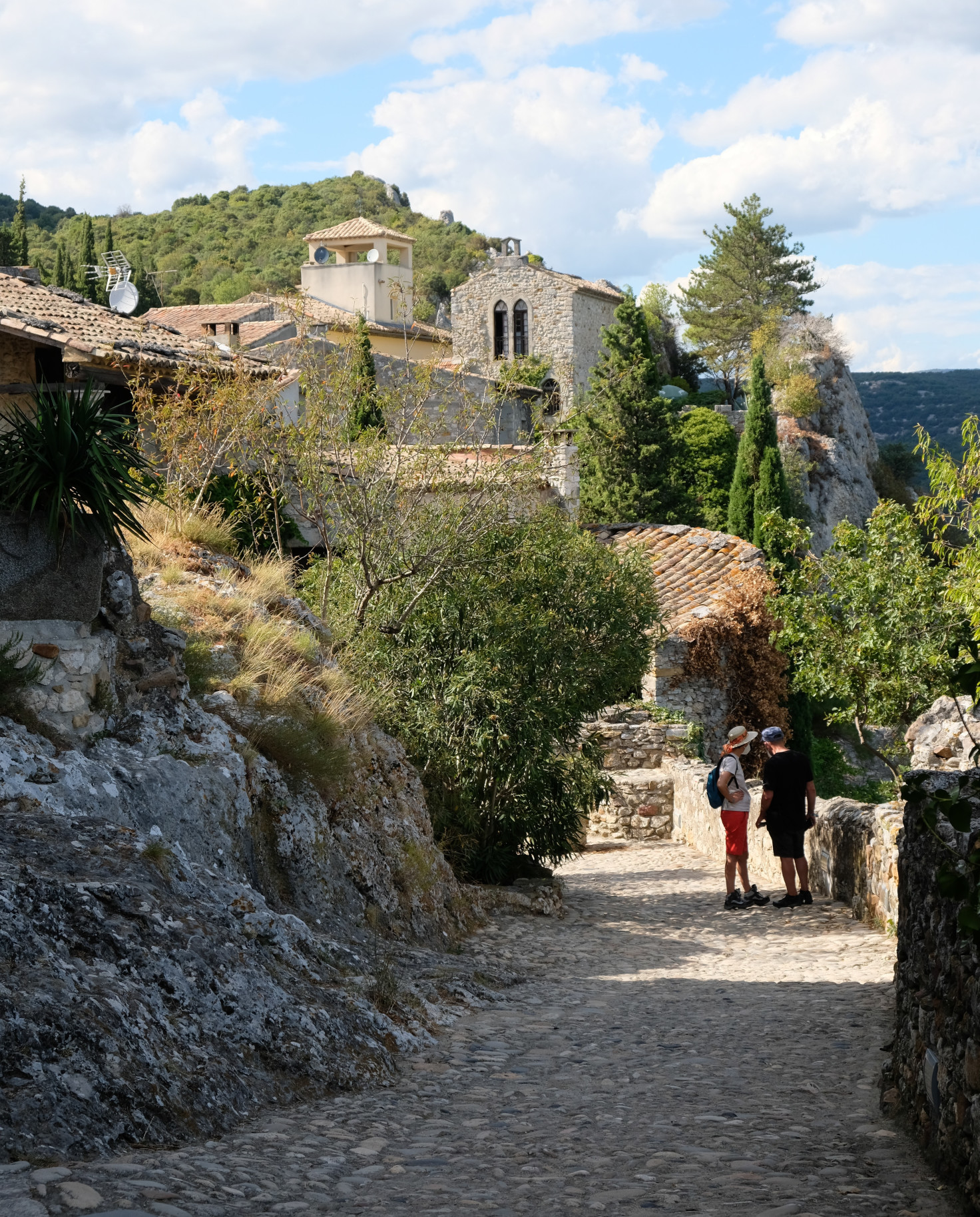 two people standing next to stone wall during daytime