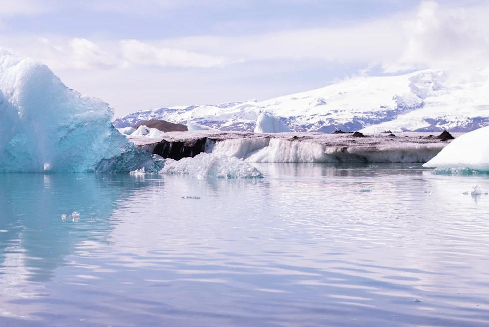 A lake with snow all around.