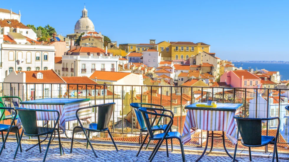 Outdoor rooftop cafe with chairs overlooking the rooftops of Lisbon. 