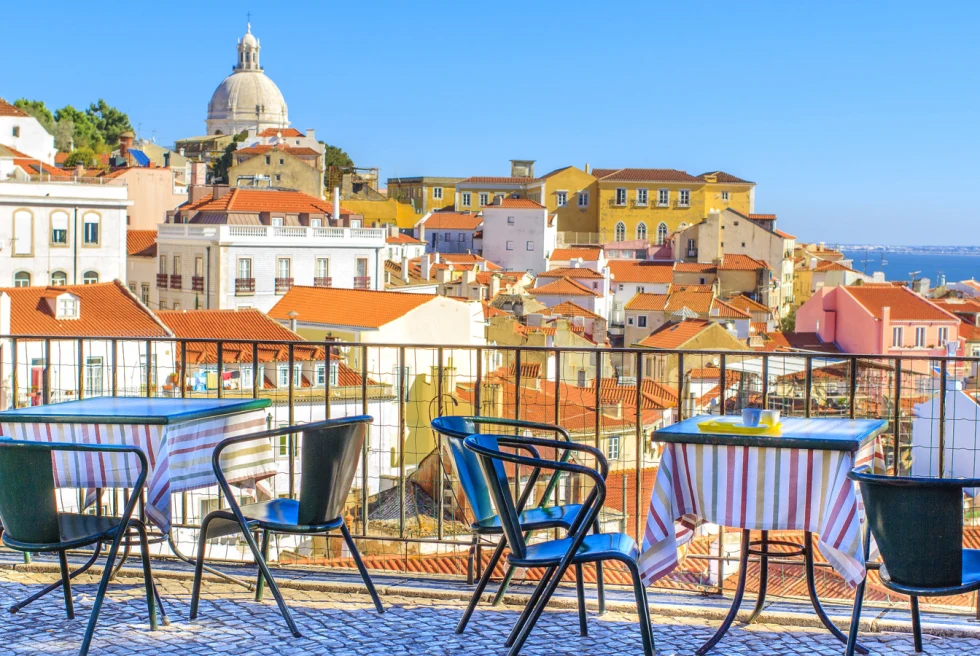 Outdoor rooftop cafe with chairs overlooking the rooftops of Lisbon. 