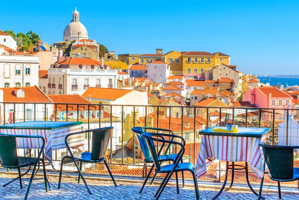Outdoor rooftop cafe with chairs overlooking the rooftops of Lisbon.