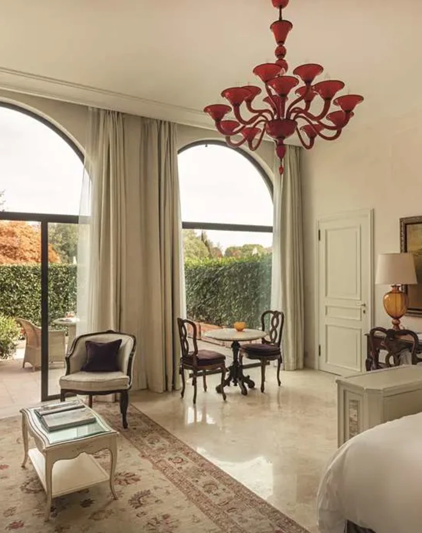 an elegant hotel room with a red artistic chandelier