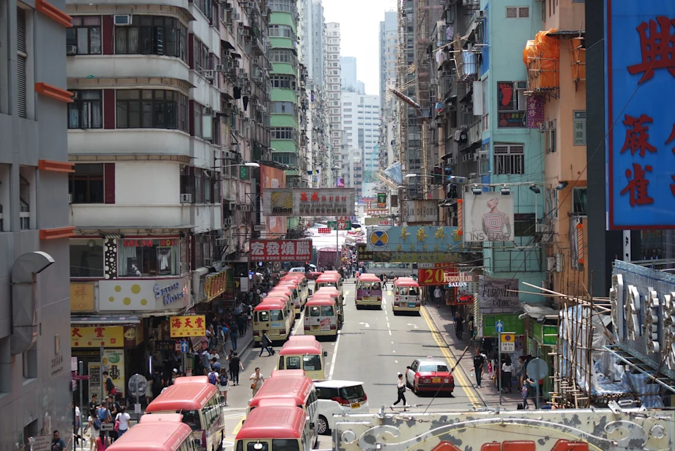busy modern city street with many red topped busses