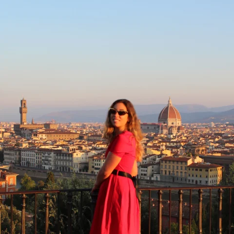 Advisor standing on a balcony with Florence skyline in the background. 