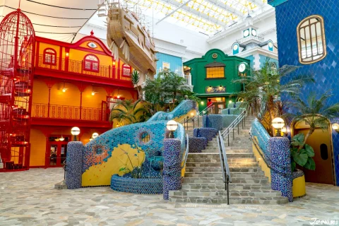 The interior of the Ghibli Park Japan, with fake colorful buildings and a stone staircase.