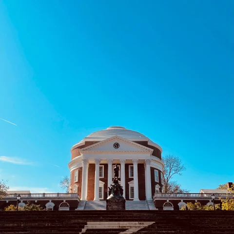 White rotunda with steps under a blue sky during daytime