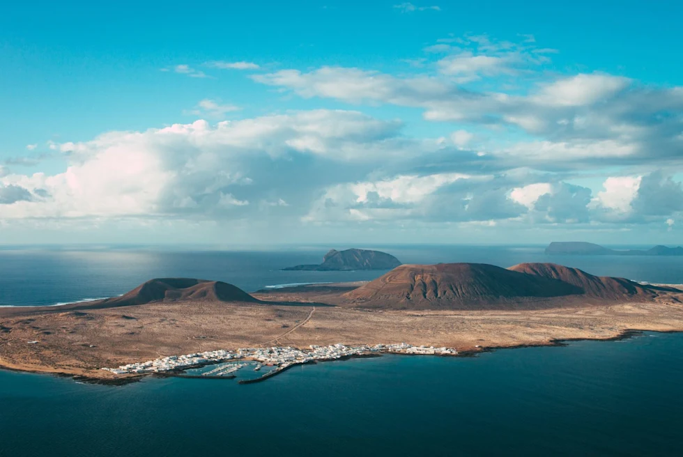 view of a flat island with sand dunes and volcanos