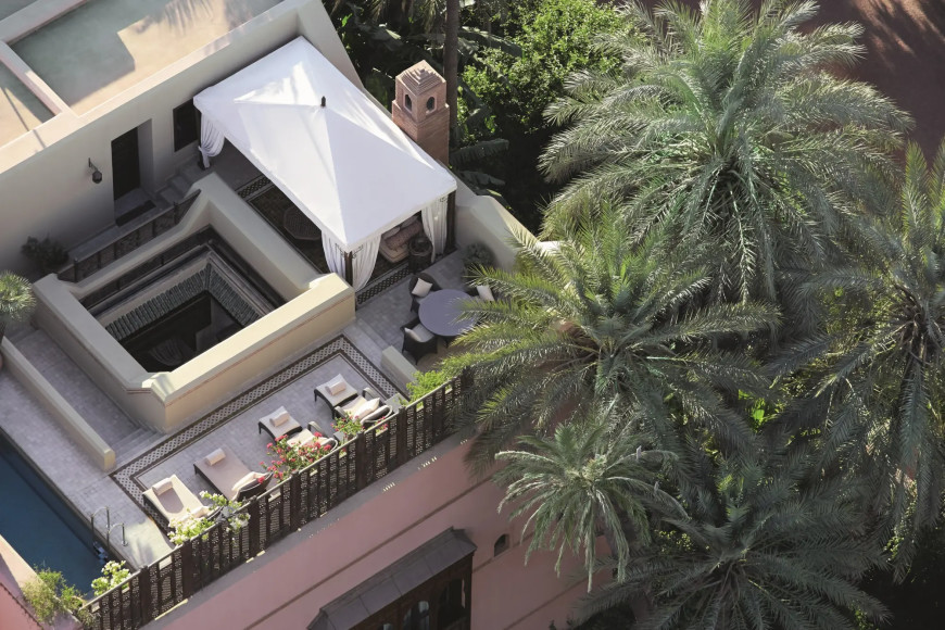 aerial view of a rooftop hang-out area partially covered by palm trees