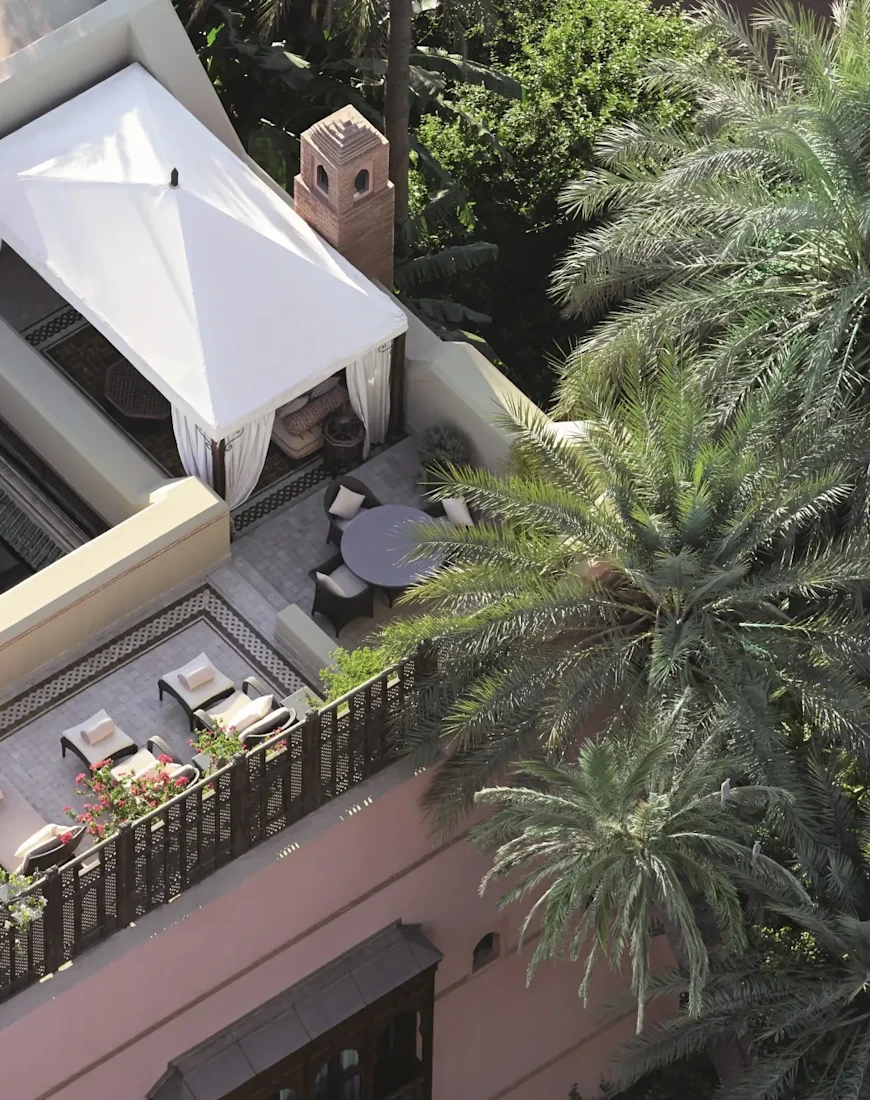 aerial view of a rooftop hang-out area partially covered by palm trees