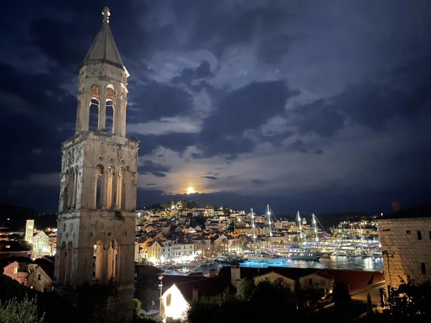 City in Hvar in Croatia at night with sun setting and cloudy sky. 