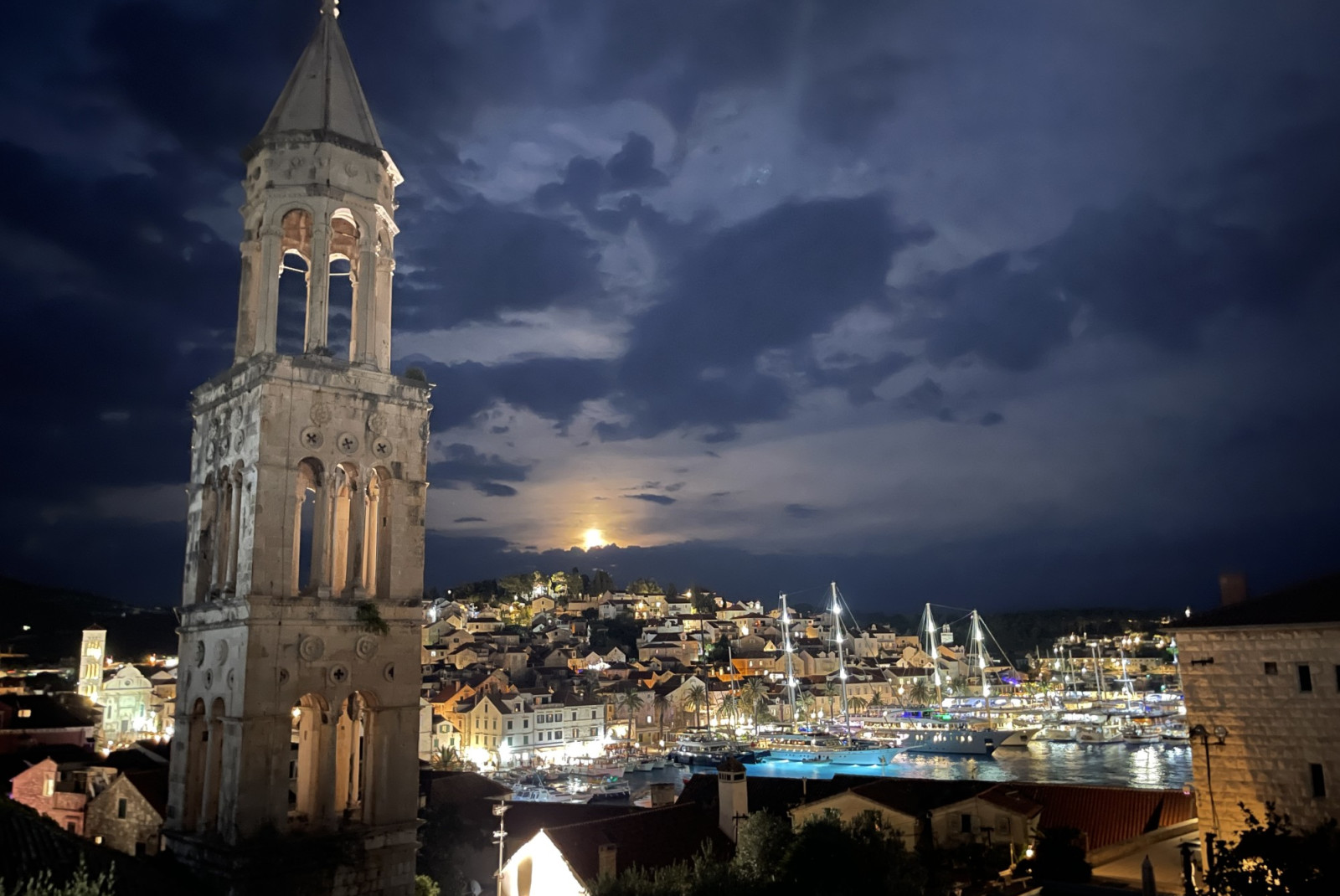 City in Hvar in Croatia at night with sun setting and cloudy sky. 