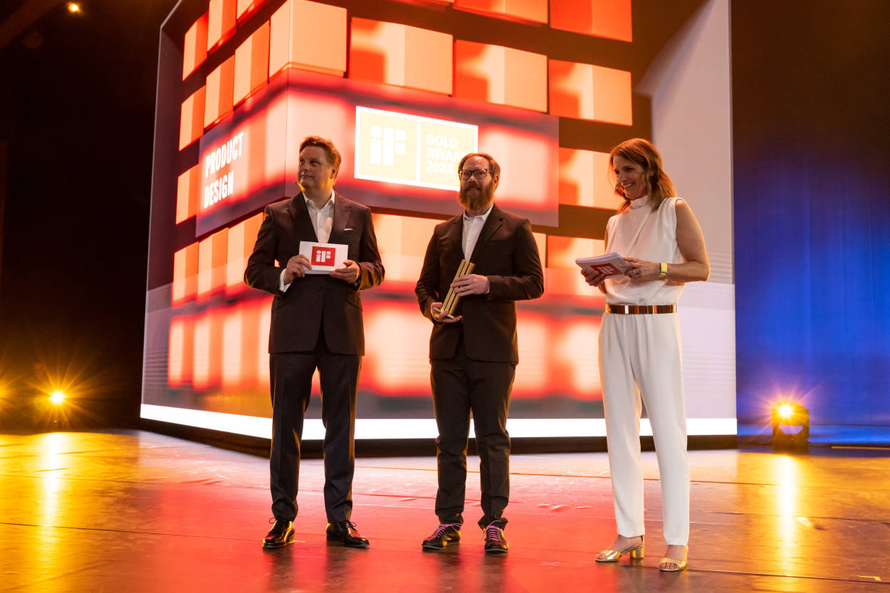 Die Gewinner des iF Design Award 2023 Gold freuen sich über ihren Erfolg und präsentieren stolz ihre Goldskulptur auf der Bühne