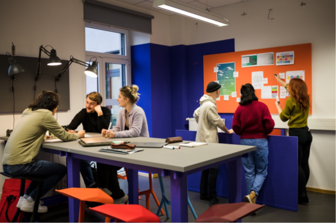 Two groups of three HAWK students discuss and exchange ideas.