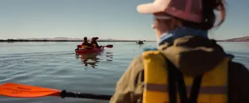 kayakers-in-gele-reddingsvesten-op-blauw-water
