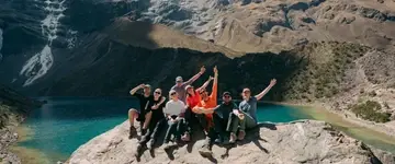 springende-reizigers-aan-turquoise-meer