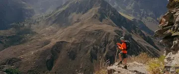 wandelaar-in-oranje-jack-op-bergpad