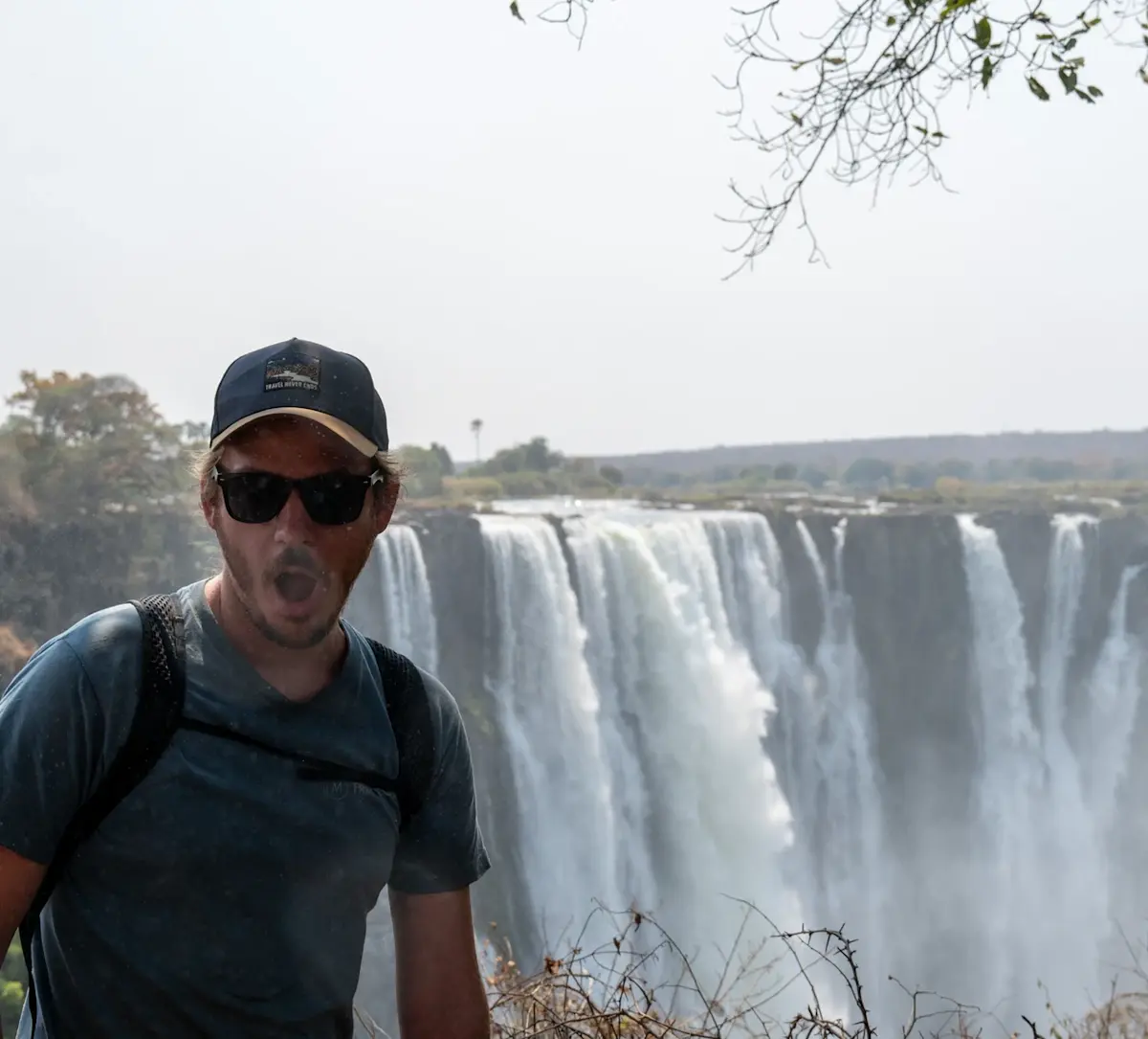 man-poseert-voor-indrukwekkende-waterval &middot; namibia-botswana-en-victoria-falls