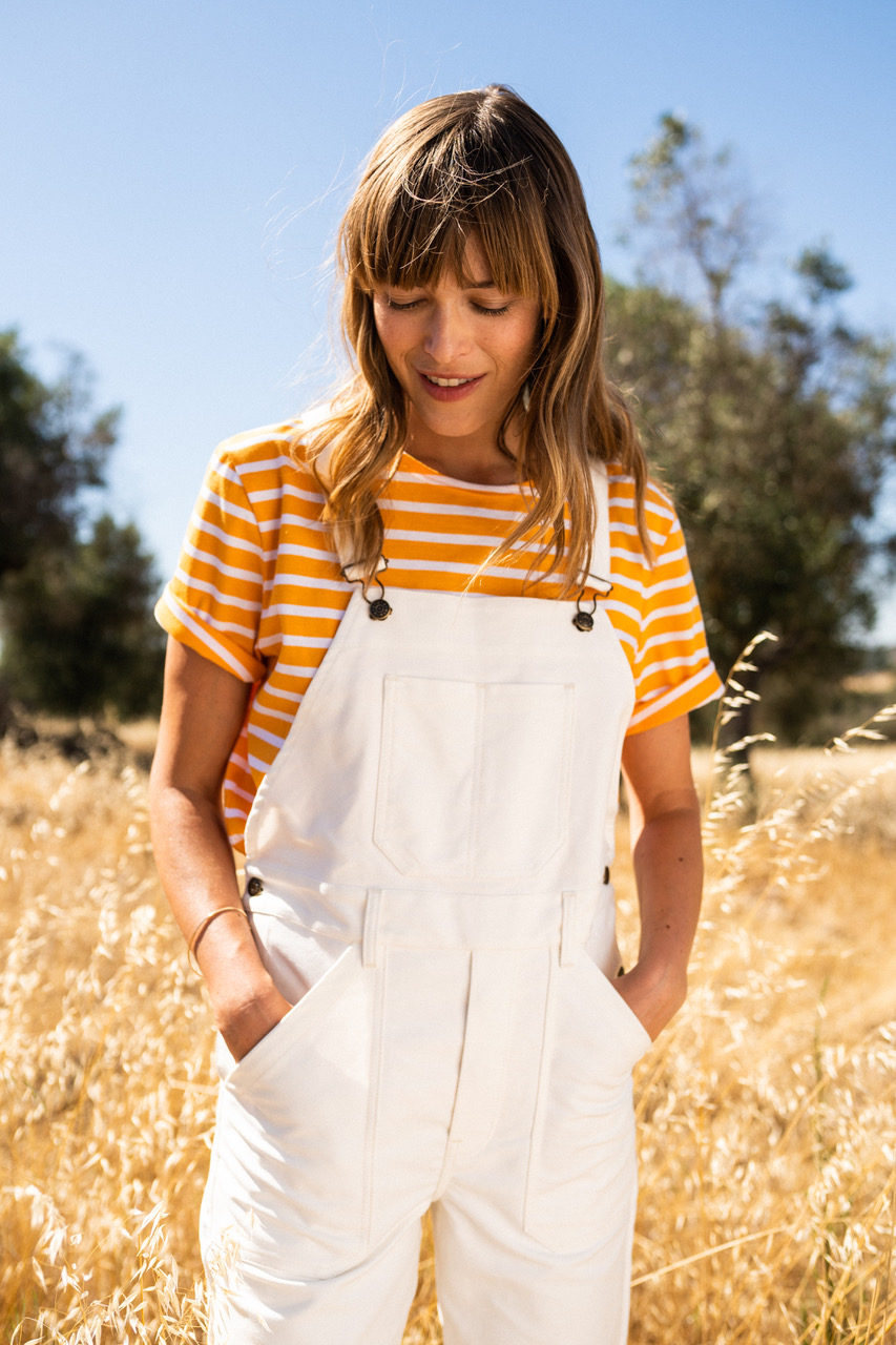 Saint james women in yellow and white horizontally striped t shirt and white dungarees 