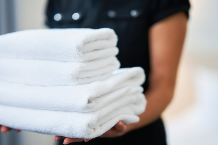 housekeeper holding folded towels