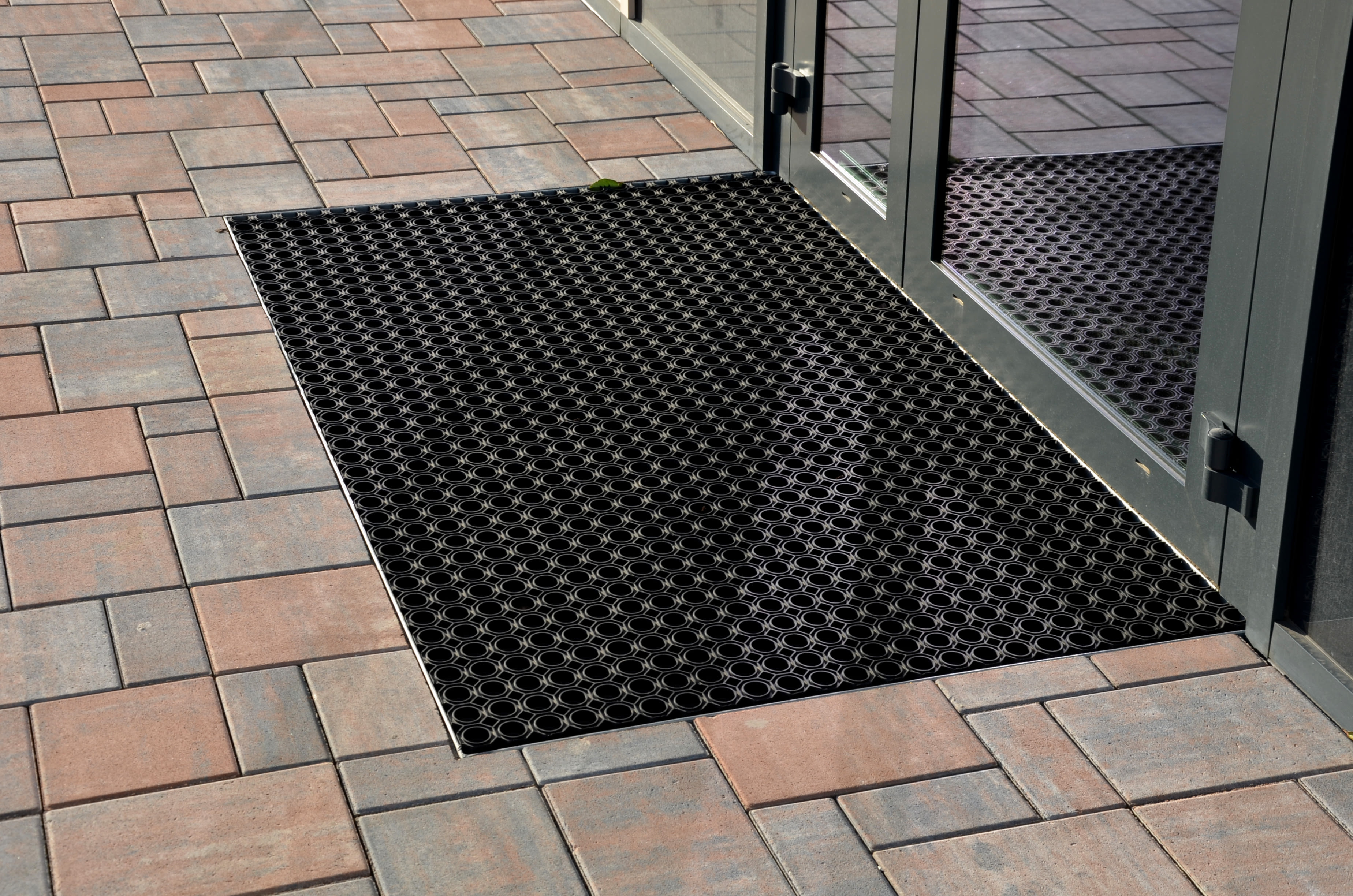 A rubber floor mat on a tile floor.