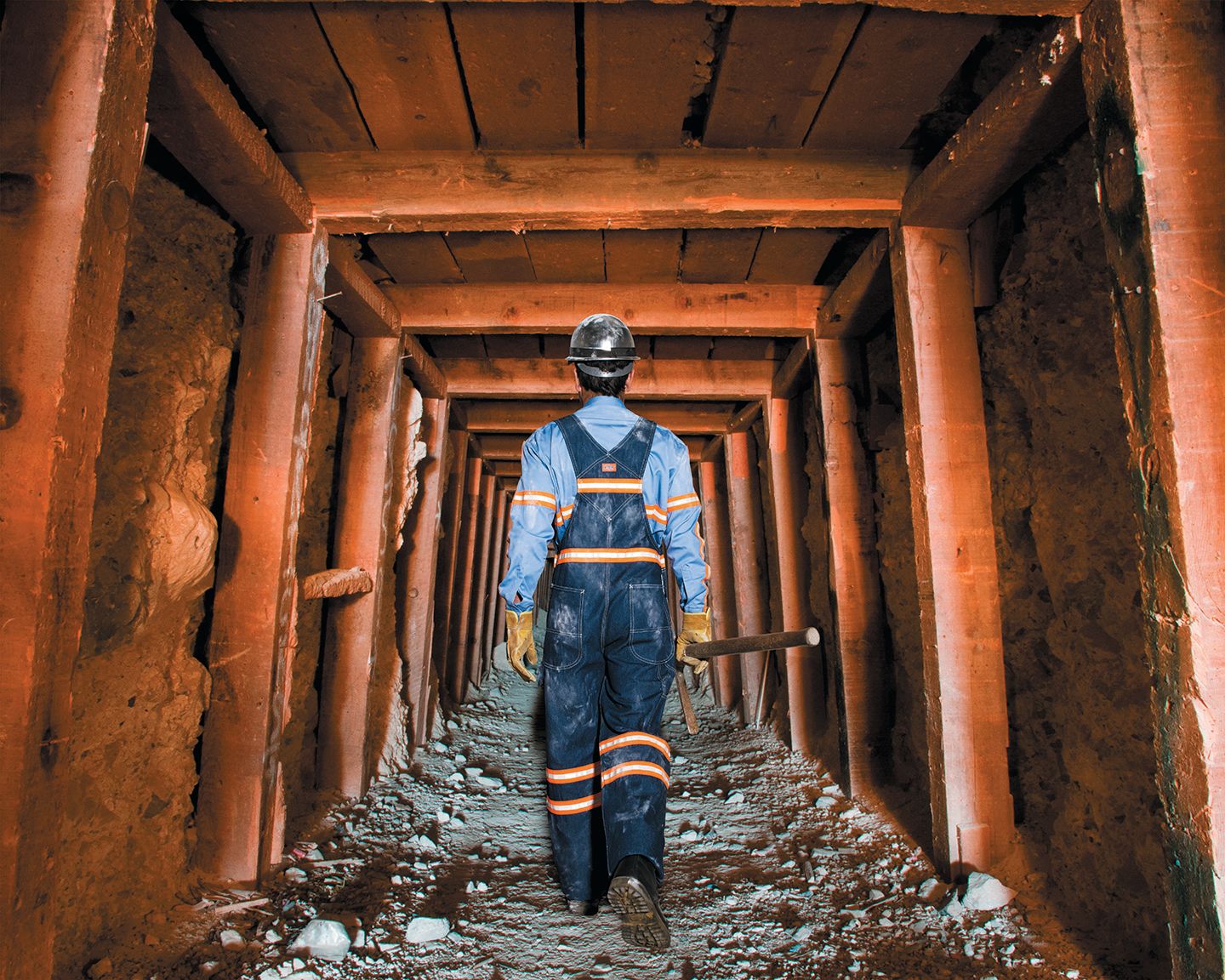Industrial worker walking in a mine shaft.