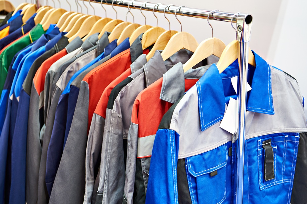 a variety of work uniforms hanging from a rack