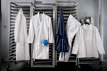 Food processing uniforms hanging on racks.