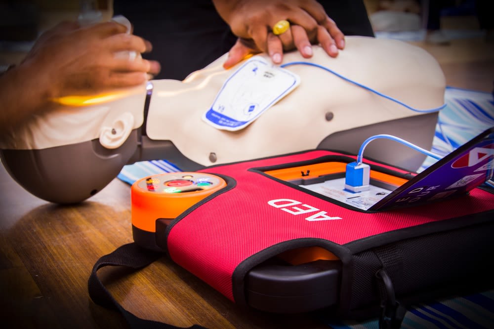 An AED kit being used on a training mannequin