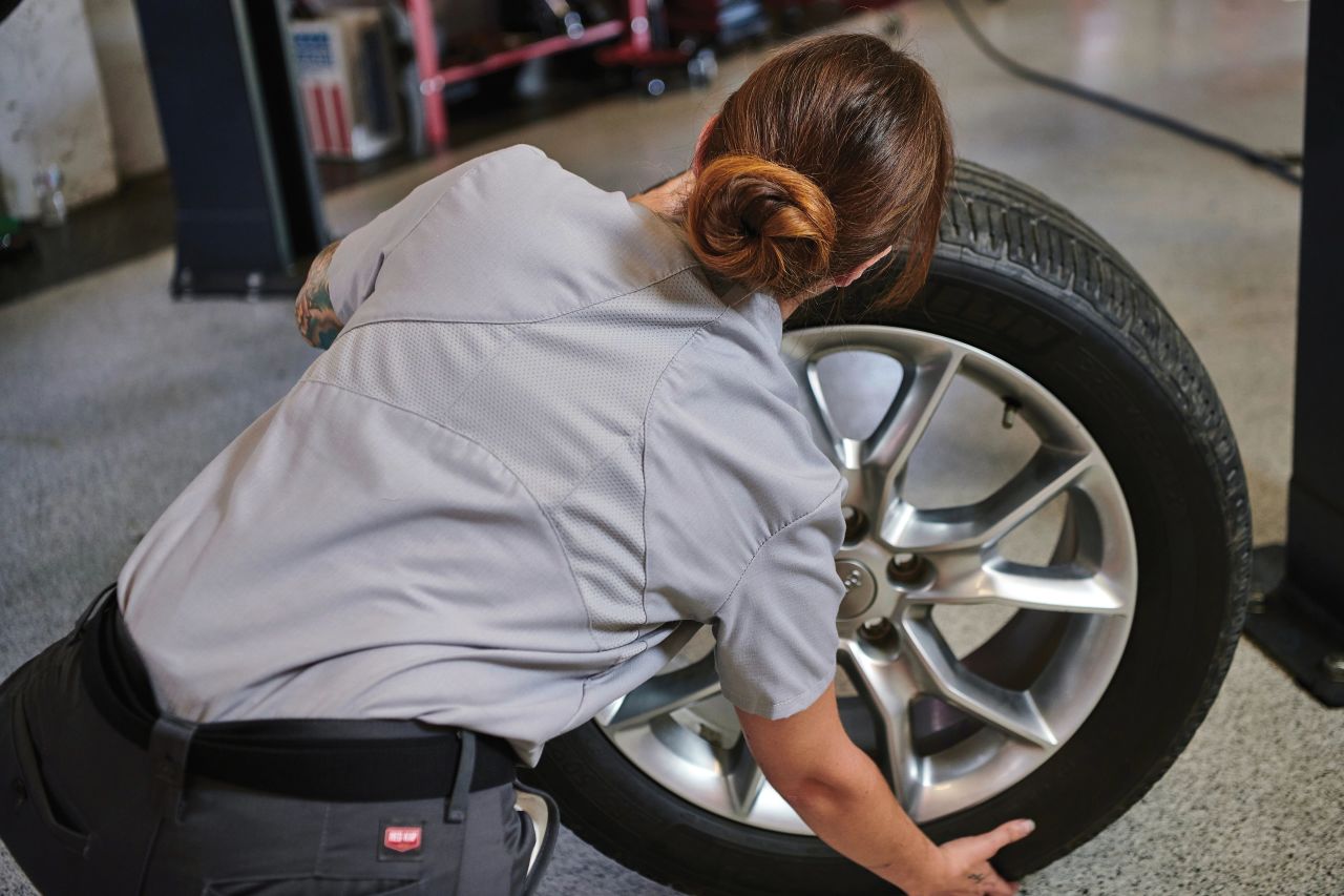 Automotive worker inspecting a tire