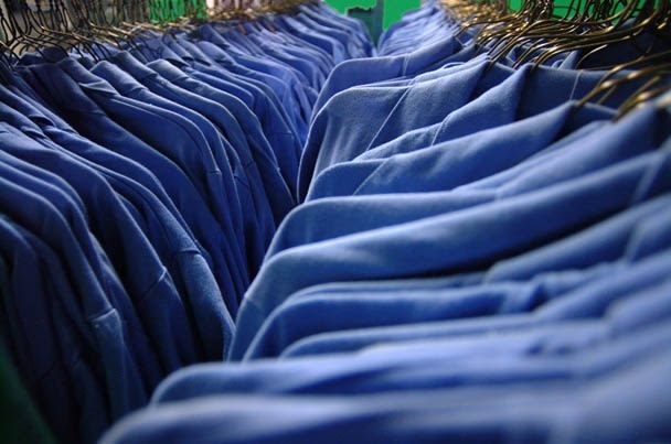 Lines of blue work shirts on hangers