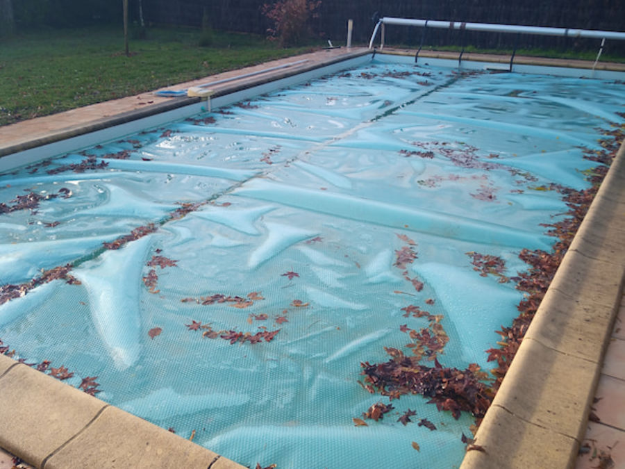 Hivernage piscine avec bâche à bulles et accumulation de feuilles