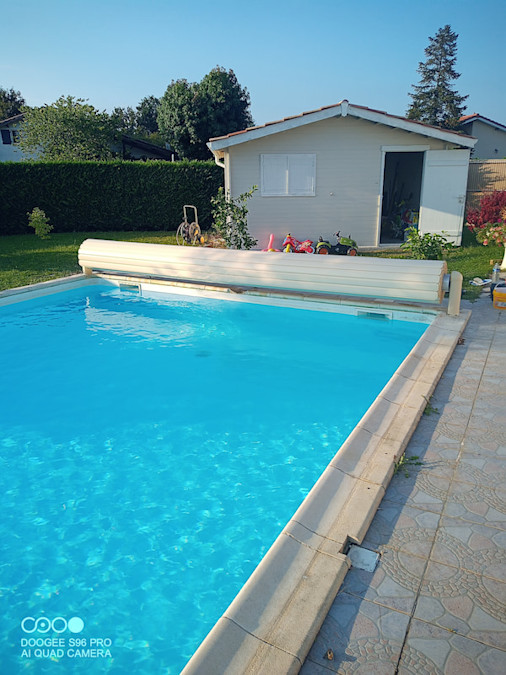 Piscine avec volet roulant et eau cristalline après rénovation