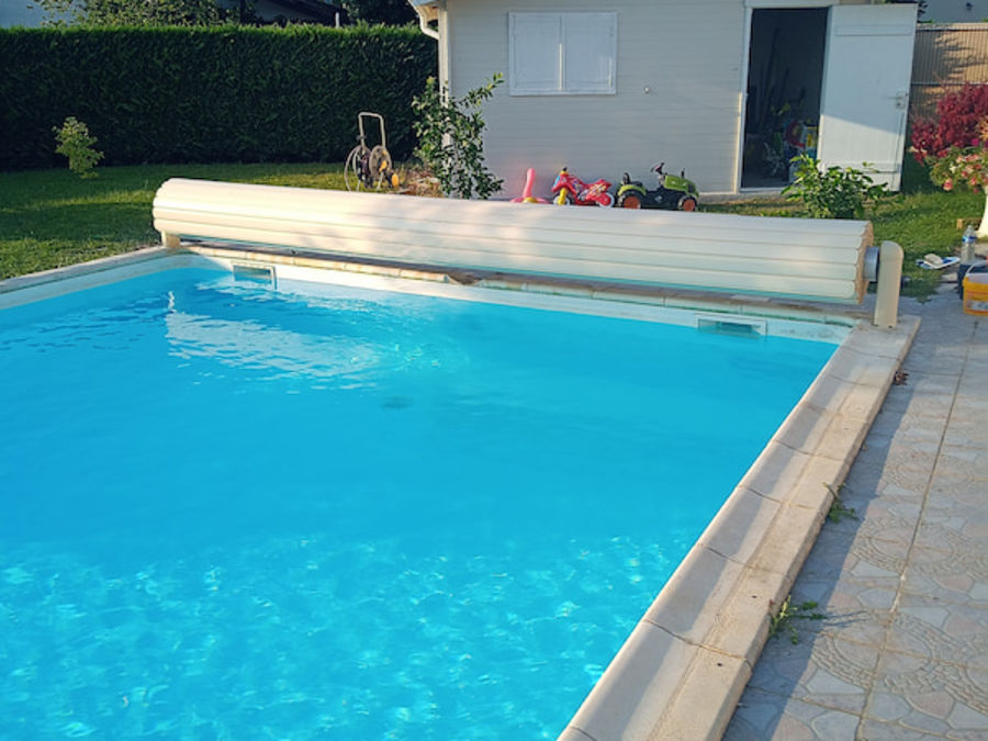 Piscine avec volet roulant et eau cristalline après rénovation