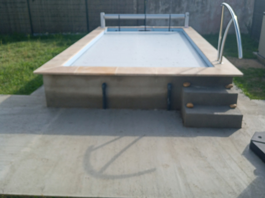 Piscine avec volet roulant fermé et aménagement extérieur