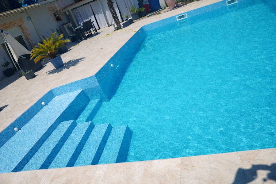 Résultat remplacement liner bleu texturé - grand bassin en L rempli avec escalier roman - Gironde