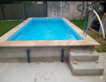 Piscine béton rénovée avec margelles et eau cristalline