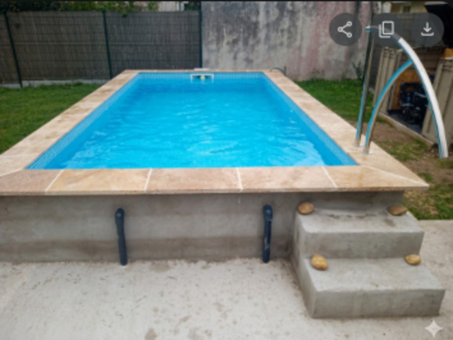 Piscine béton rénovée avec margelles et eau cristalline